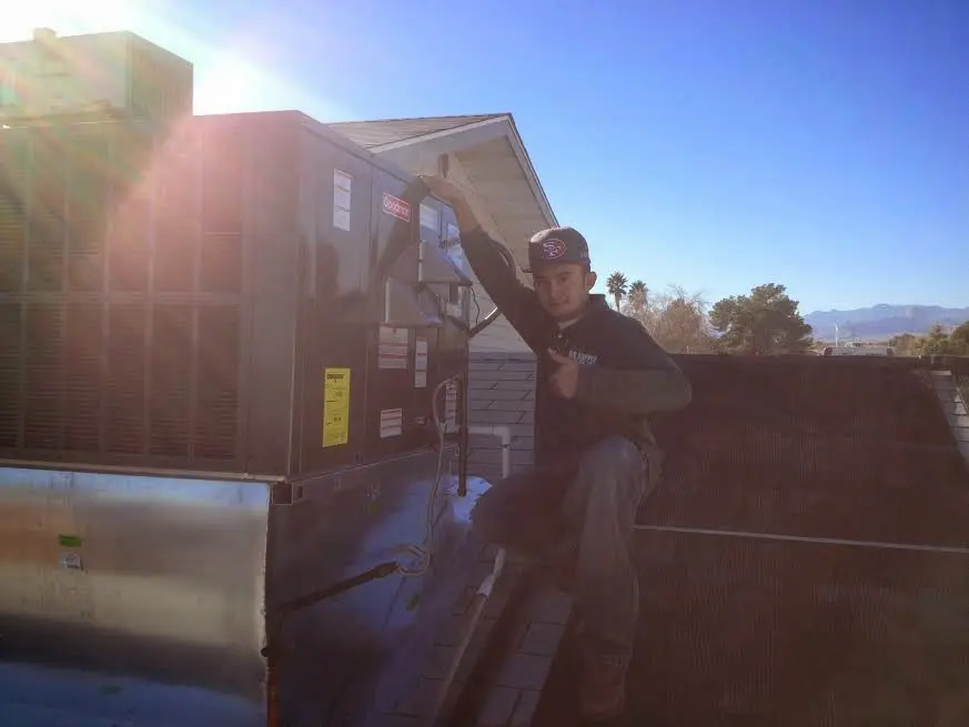 HVAC technician performing Air Duct Cleaning on a rooftop unit in Pittsgrove